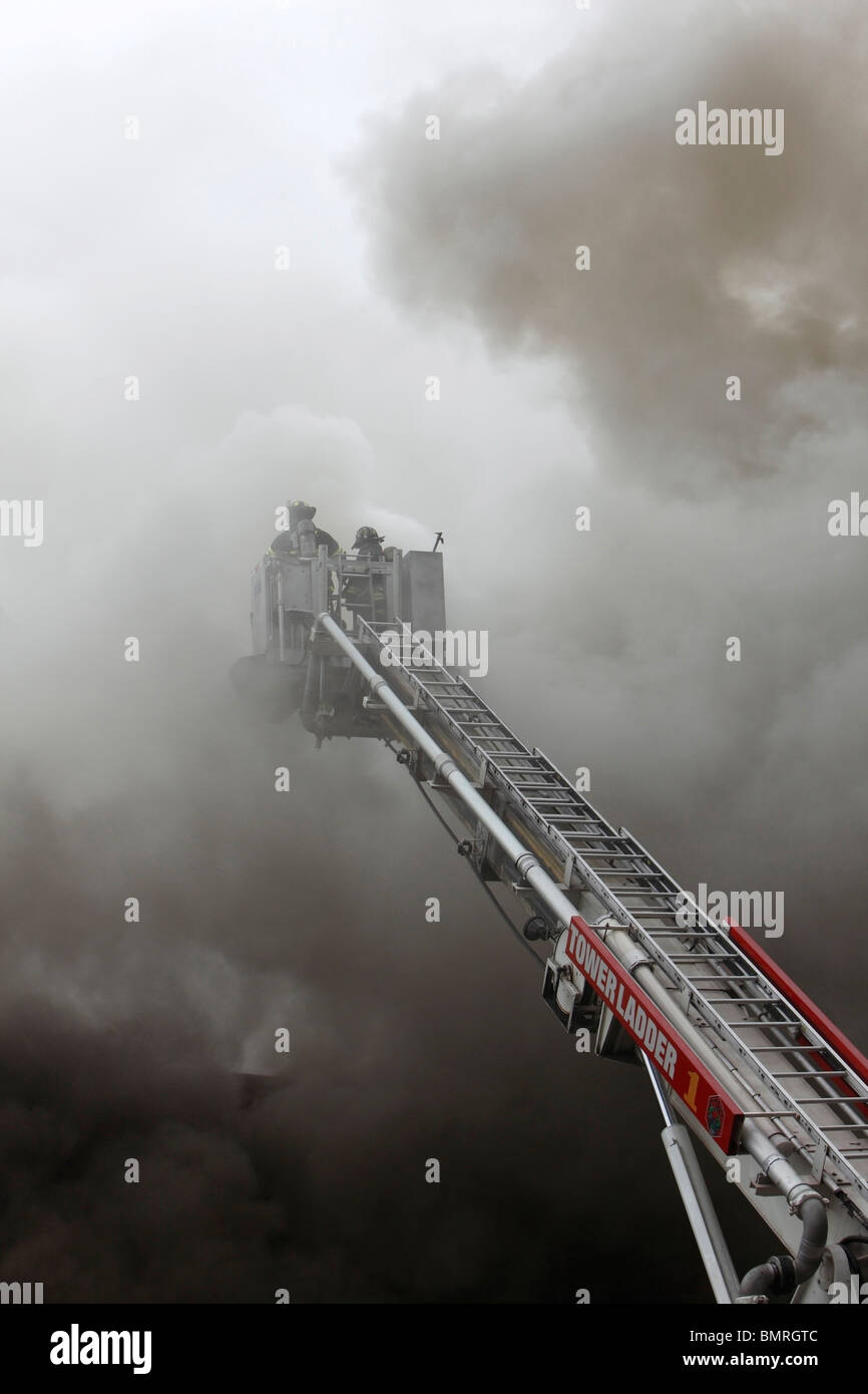 Pompier luttant contre un smoky blaze Banque D'Images