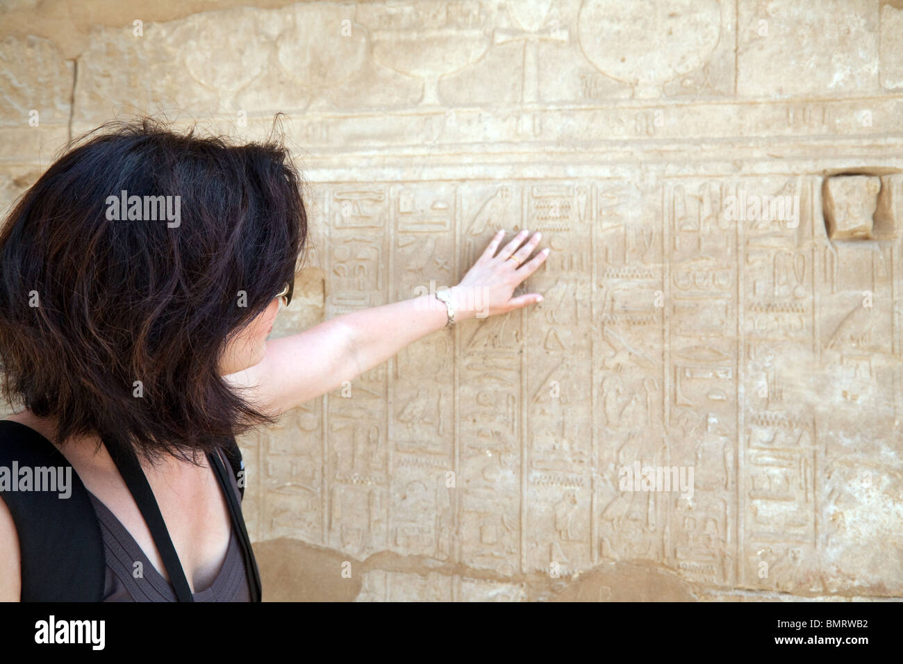 Une touriste examinant les hiéroglyphes sculptés, Temple de Karnak, Louxor, Egypte Banque D'Images