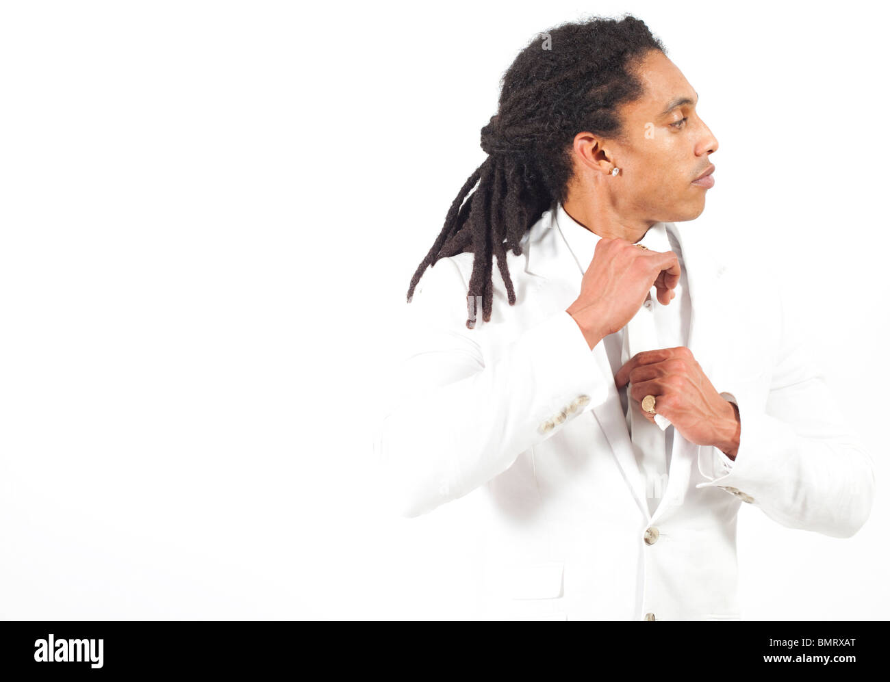 Portrait d'un homme cubain avec des dreadlocks, portant un costume blanc, sur fond blanc. Banque D'Images