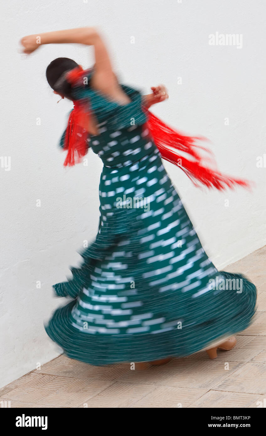 Flou de mouvement d'obturation lente shot of woman spinning danseuse de flamenco espagnol traditionnel et danser en robe à pois vert Banque D'Images