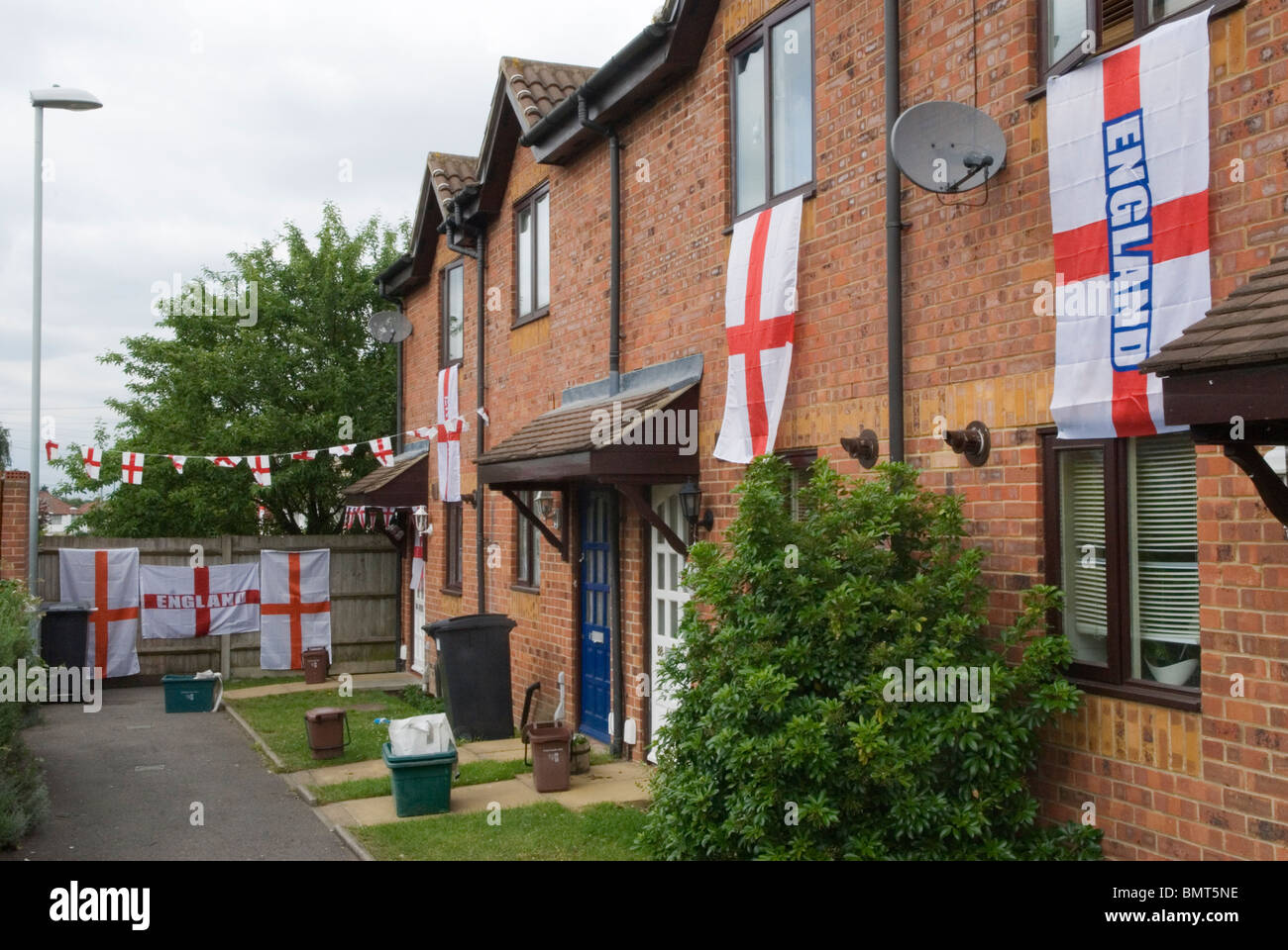 Des drapeaux anglais décoraient la maison d'un fan de la coupe du monde de football de l'Angleterre. Décorer une rangée de maisons ordinaires de banlieue londonienne. ANNÉES 2010 2010 ROYAUME-UNI HOMER SYKES Banque D'Images