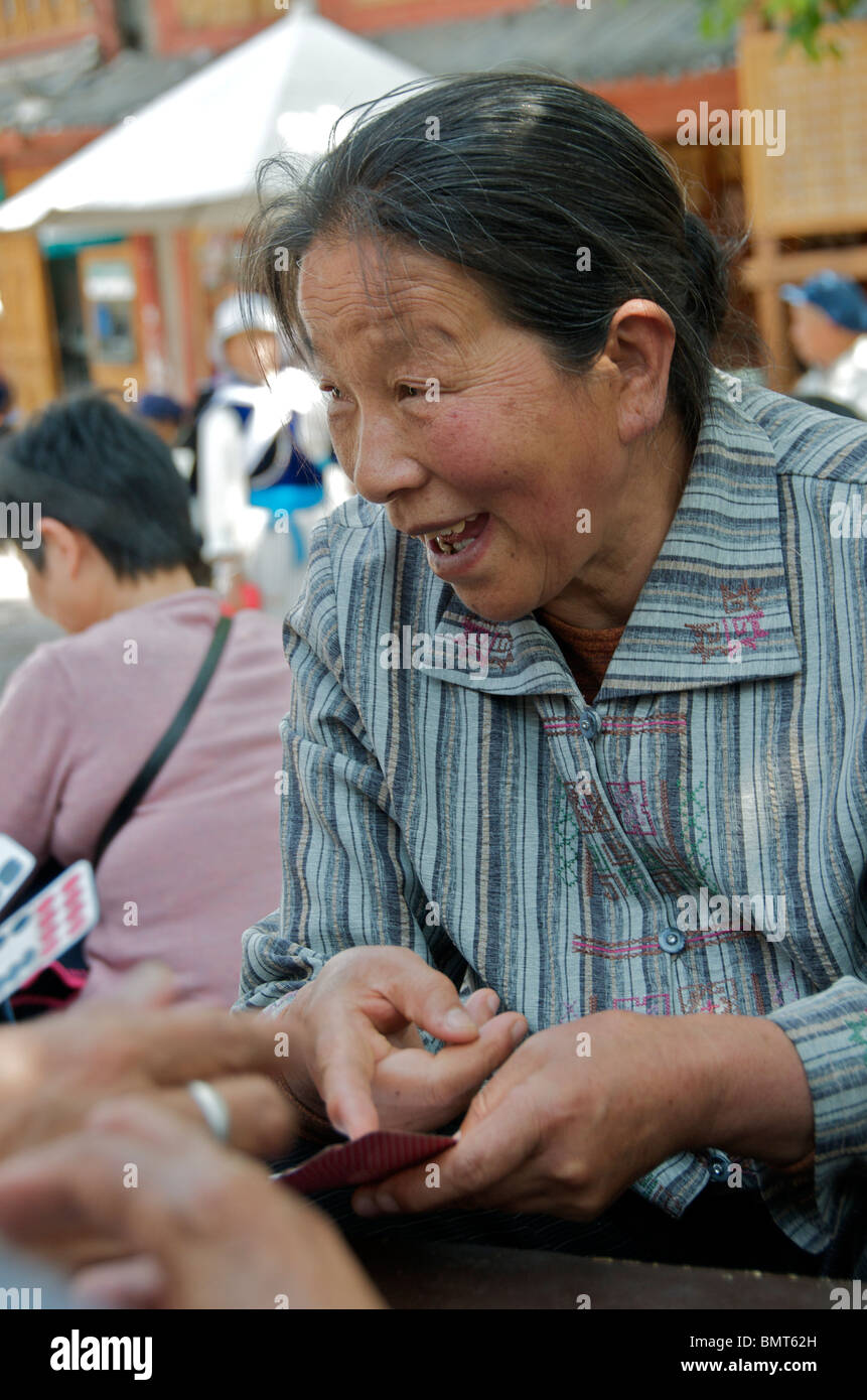 Laughing woman jouer jeu de cartes chinois place 52/7 Dongkang de Lijiang Yunnan Chine Banque D'Images