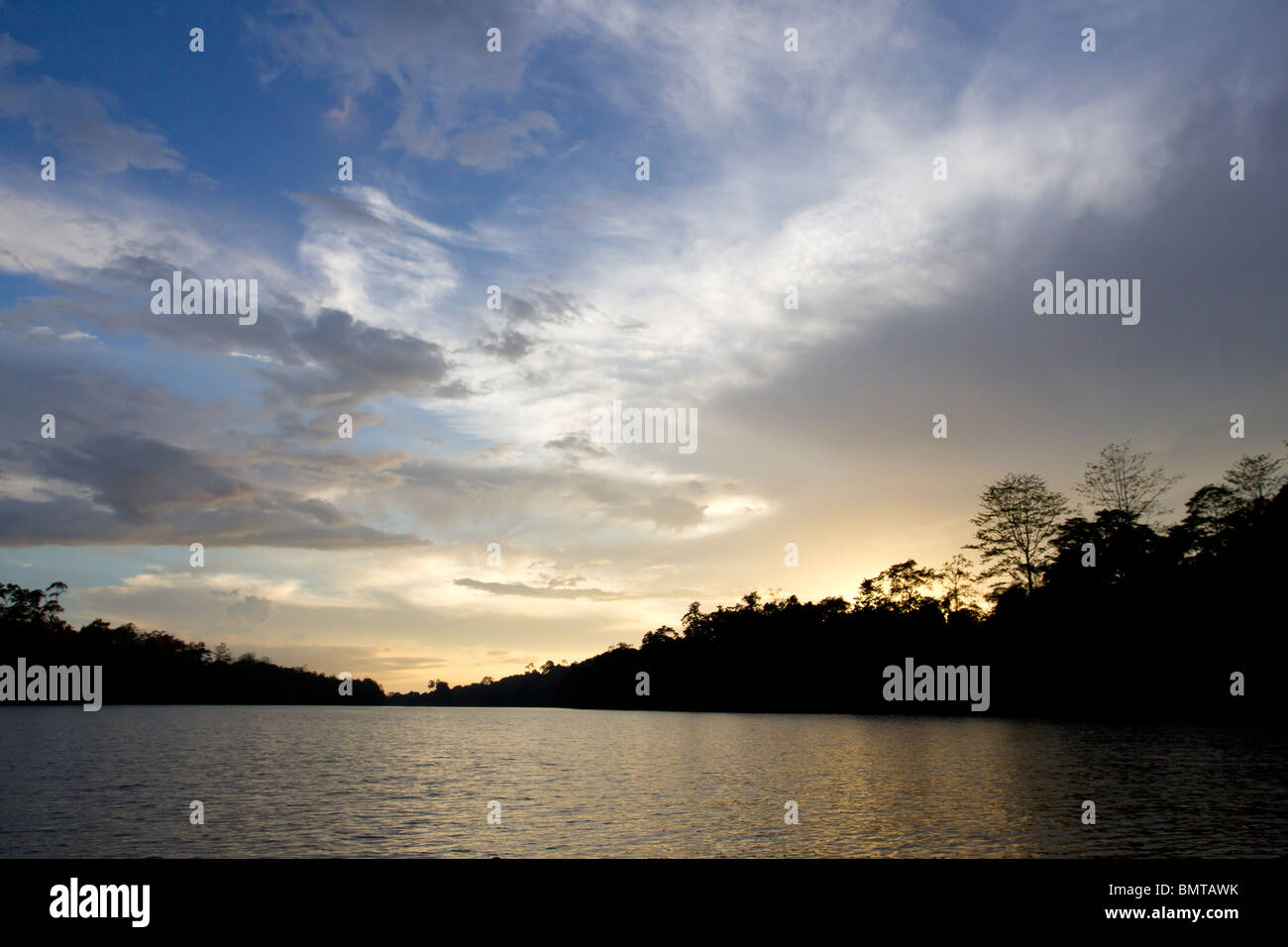 Coucher de soleil nuageux avec silhouette d'arbres et forêt sur la rivière Kinabatangan, Sabah, Bornéo, Malaisie. Banque D'Images