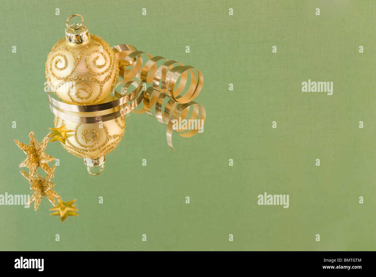 Modèle de défilement d'or Boule de Noël sur fond vert tendre avec copyspace Banque D'Images