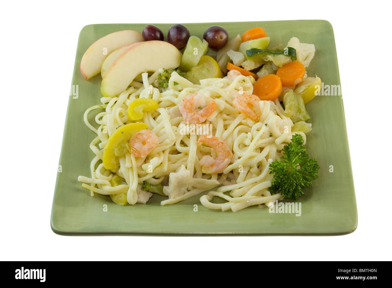 Nouilles crevettes repas sur plaque verte avec macédoine de légumes et des tranches de pomme Banque D'Images