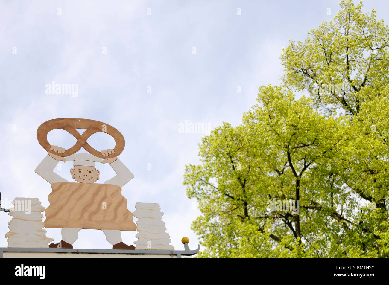 Außenwerbung mit ; figure, die ein Brezel hält. - La publicité extérieure d'une boulangerie ; la figure qui est titulaire d'un bretzel. Banque D'Images