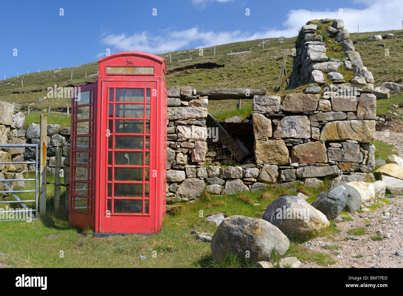 Old style red UK téléphone fort à côté d'une épave croft house Banque D'Images