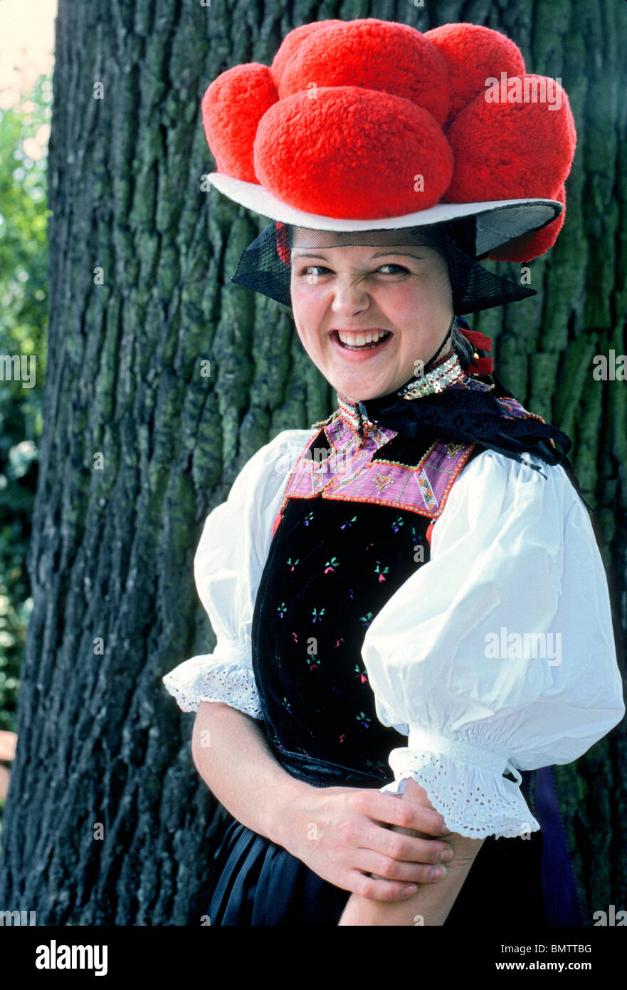 A smiling girl allemande à un festival culturel dans la Forêt Noire de  l'Allemagne porte un chapeau traditionnel avec des pompons rouge indique  qu'elle n'est pas mariée Photo Stock - Alamy
