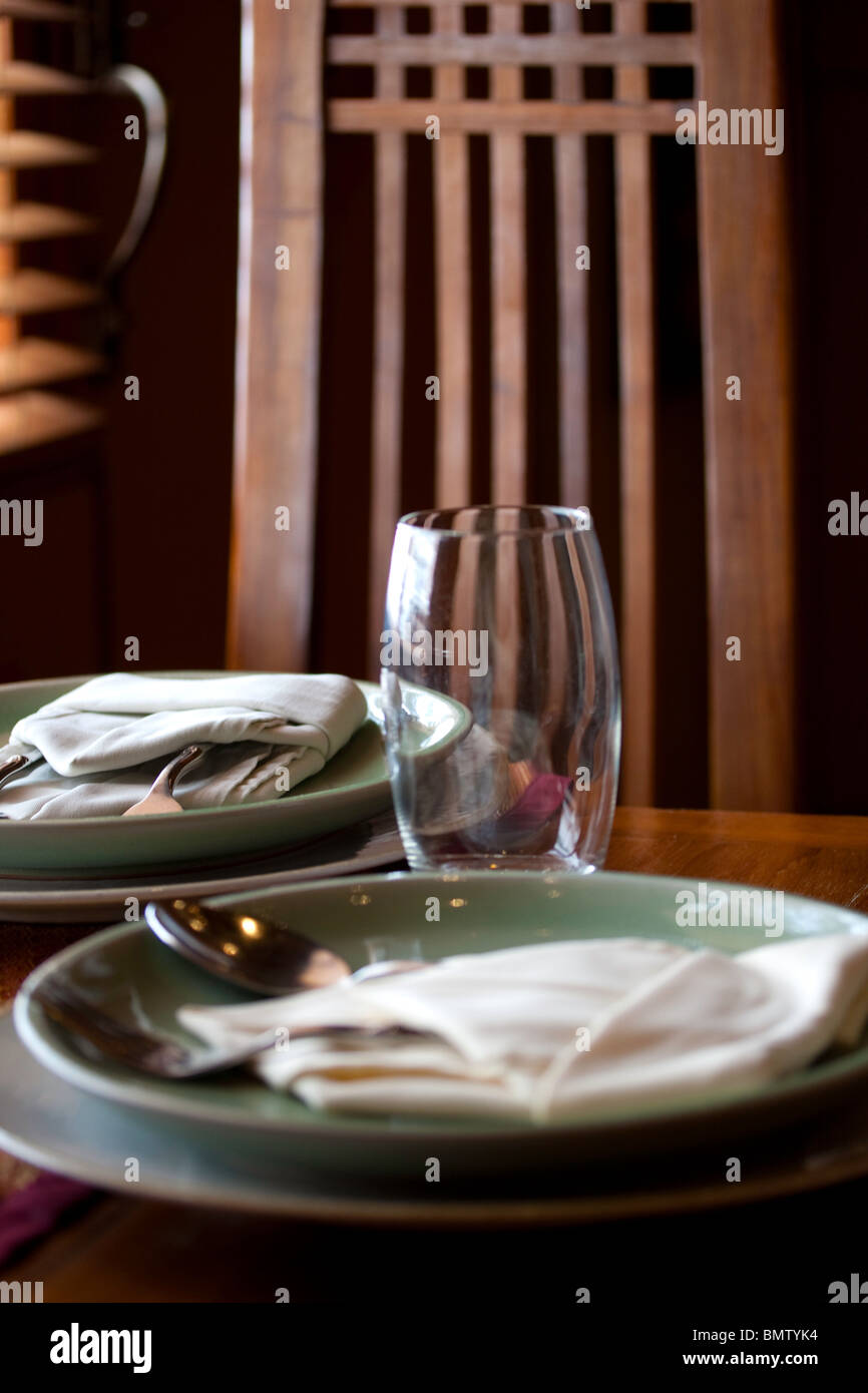 Réglage de la table pour deux avec des lunettes, cuillère, fourchette, assiette, serviette en tissu et dossier de chaise Banque D'Images