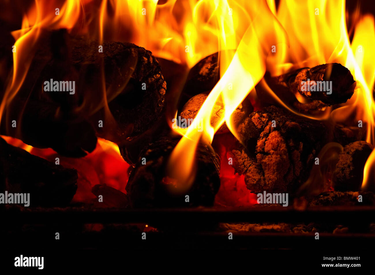 Bûches silhouetté contre flammes dans un foyer. Banque D'Images