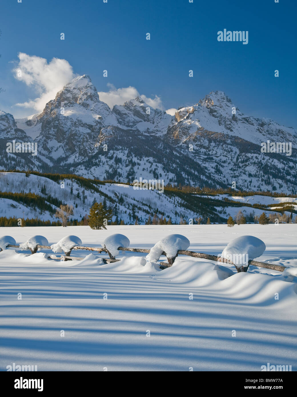 Parc National de Grand Teton, Wyoming enneigés des ligne de clôture avec les sommets de la chaîne Teton dans la lumière d'hiver Banque D'Images