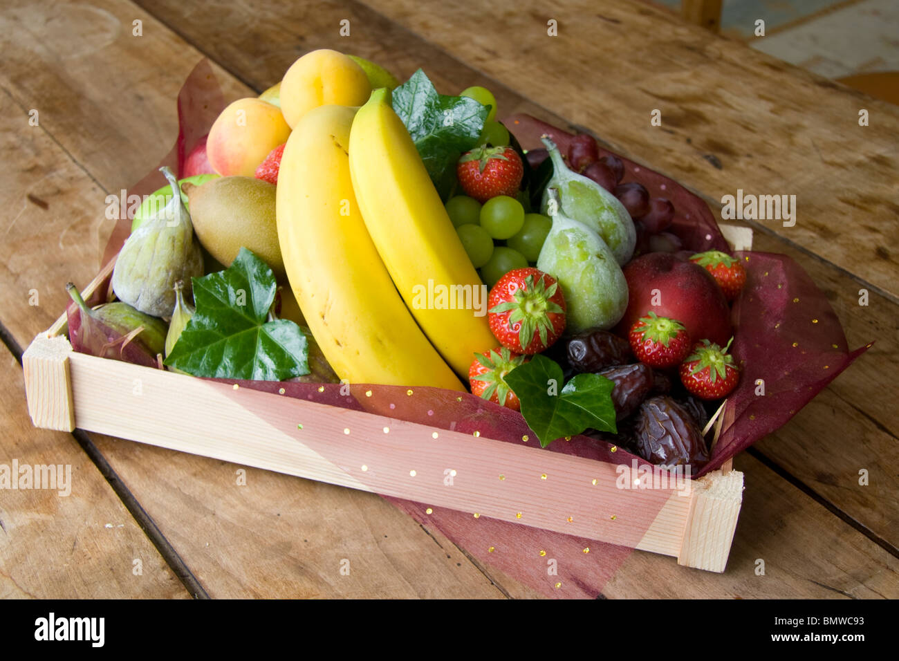 Une pile de fruits dans un punnett avec fig's fraise banane raisins kiwi Banque D'Images