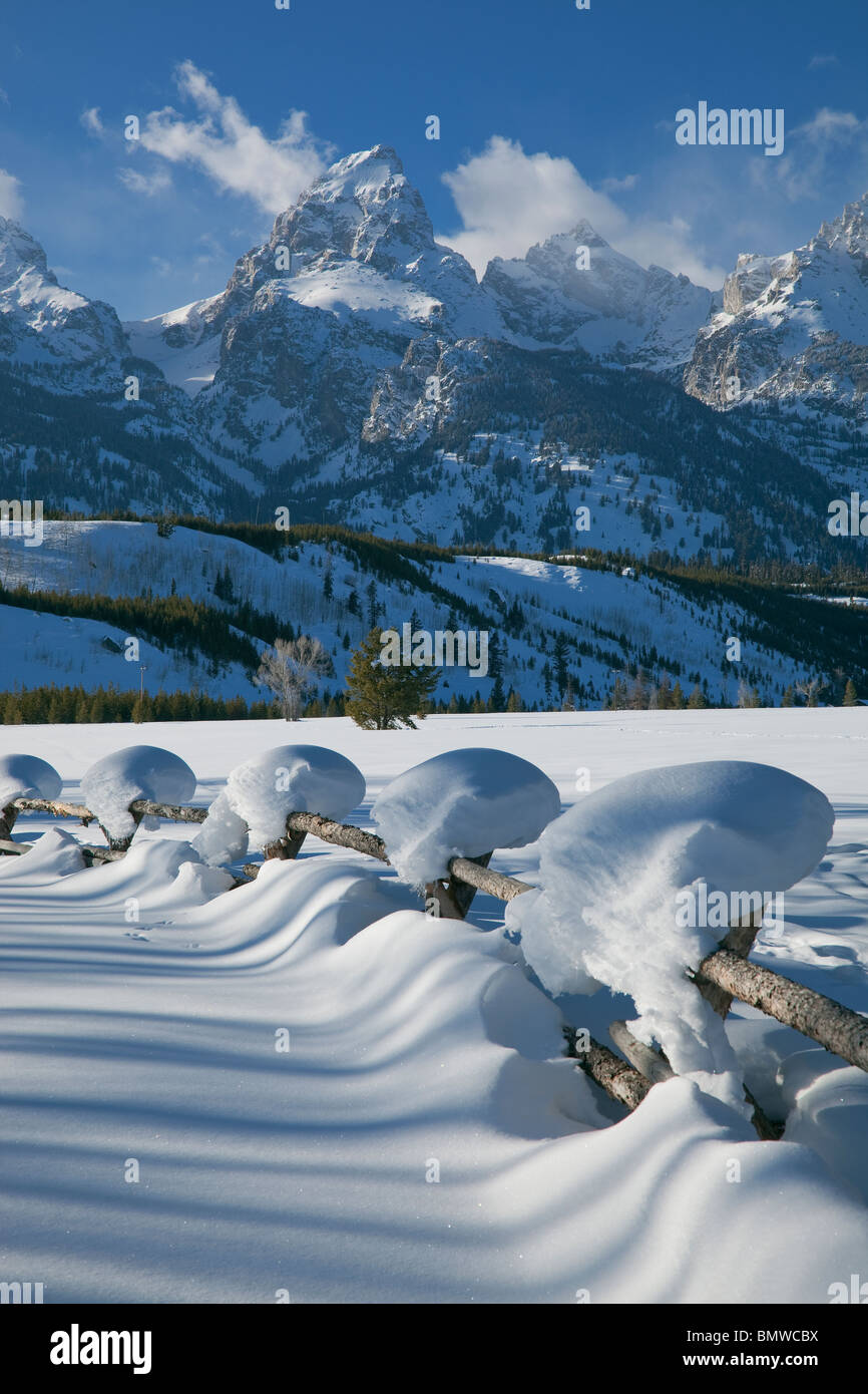 Parc National de Grand Teton, Wyoming enneigés des ligne de clôture avec les sommets de la chaîne Teton dans la lumière d'hiver Banque D'Images