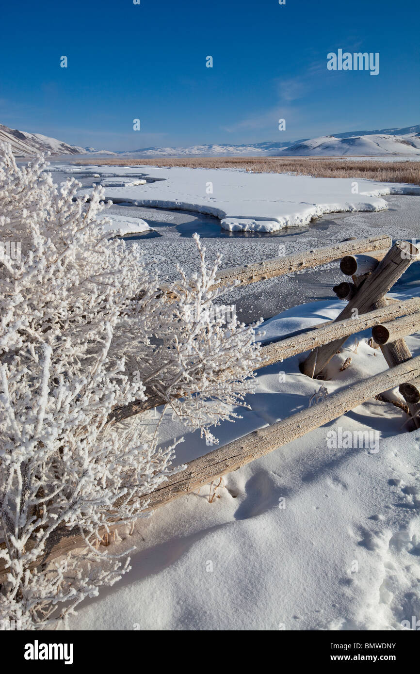 Jackson Hole, Wyoming L'hiver la lumière du matin sur la ligne de clôture dépoli au-dessus d'un plat congelé Creek dans le National Elk Refuge Banque D'Images