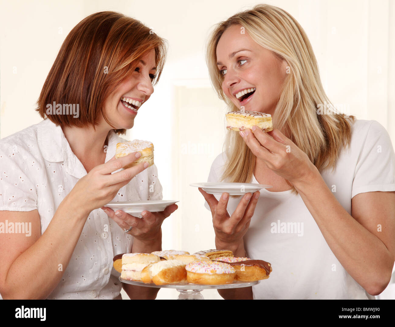 Deux femmes de manger des gâteaux à la crème Banque D'Images