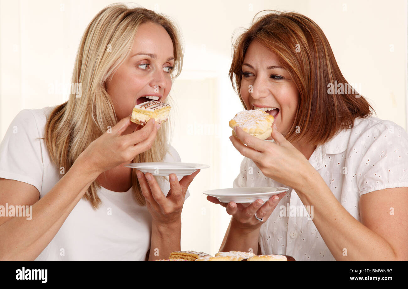 Deux femmes de manger des gâteaux à la crème Banque D'Images