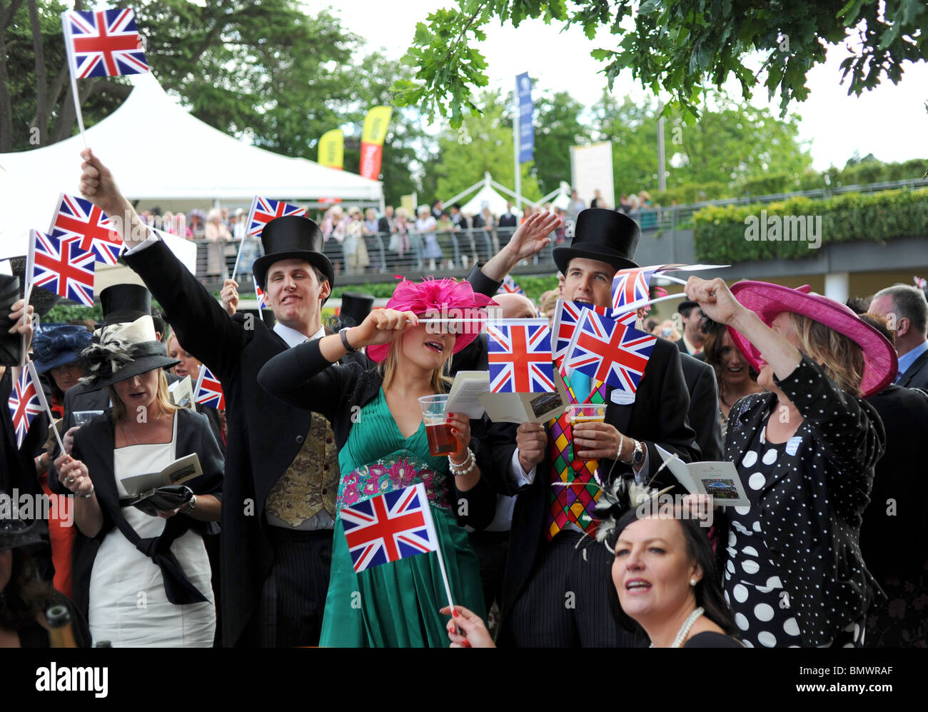 Royal Ascot Berkshire - Racegoers profiter de la traditionnelle fin de journée singsong au kiosque avec l'Union jack drapeaux pour wave Banque D'Images