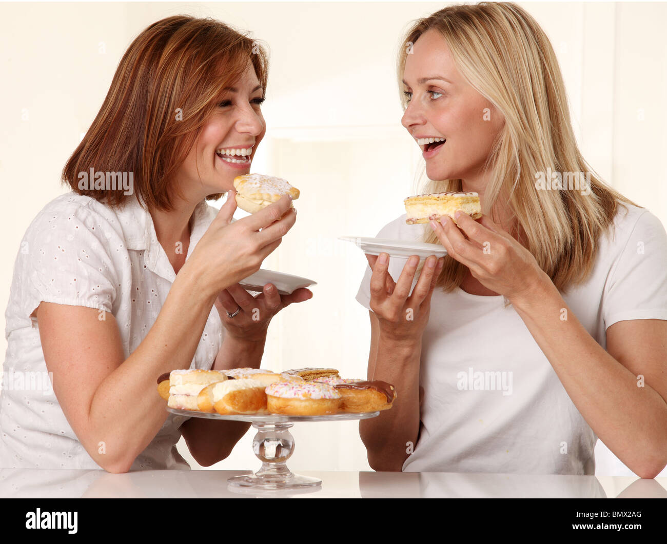 Deux femmes de manger des gâteaux à la crème Banque D'Images