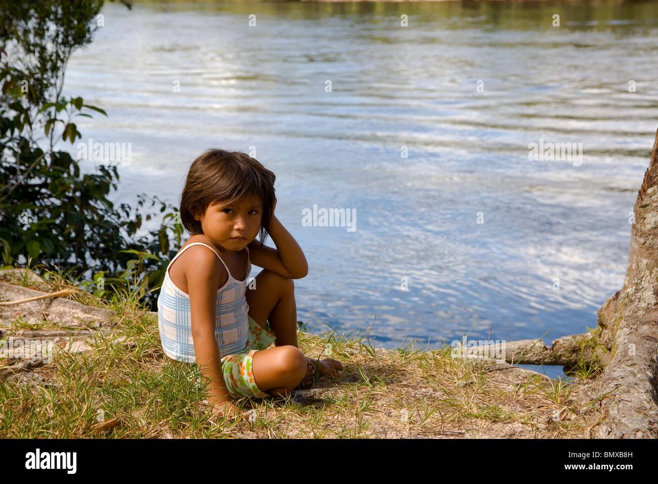 Une tribu Pemon enfant autochtone s'asseoir à la banque de l'un d'Canaimas complexe River à tout droit à l'objectif Banque D'Images