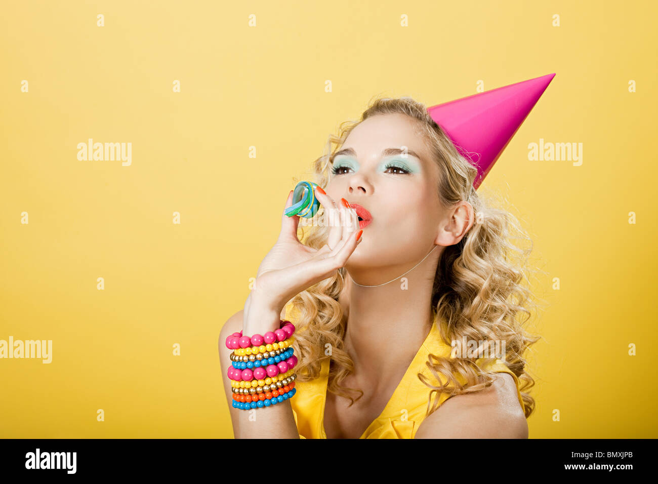 Young woman wearing party hat avec party streamer Banque D'Images