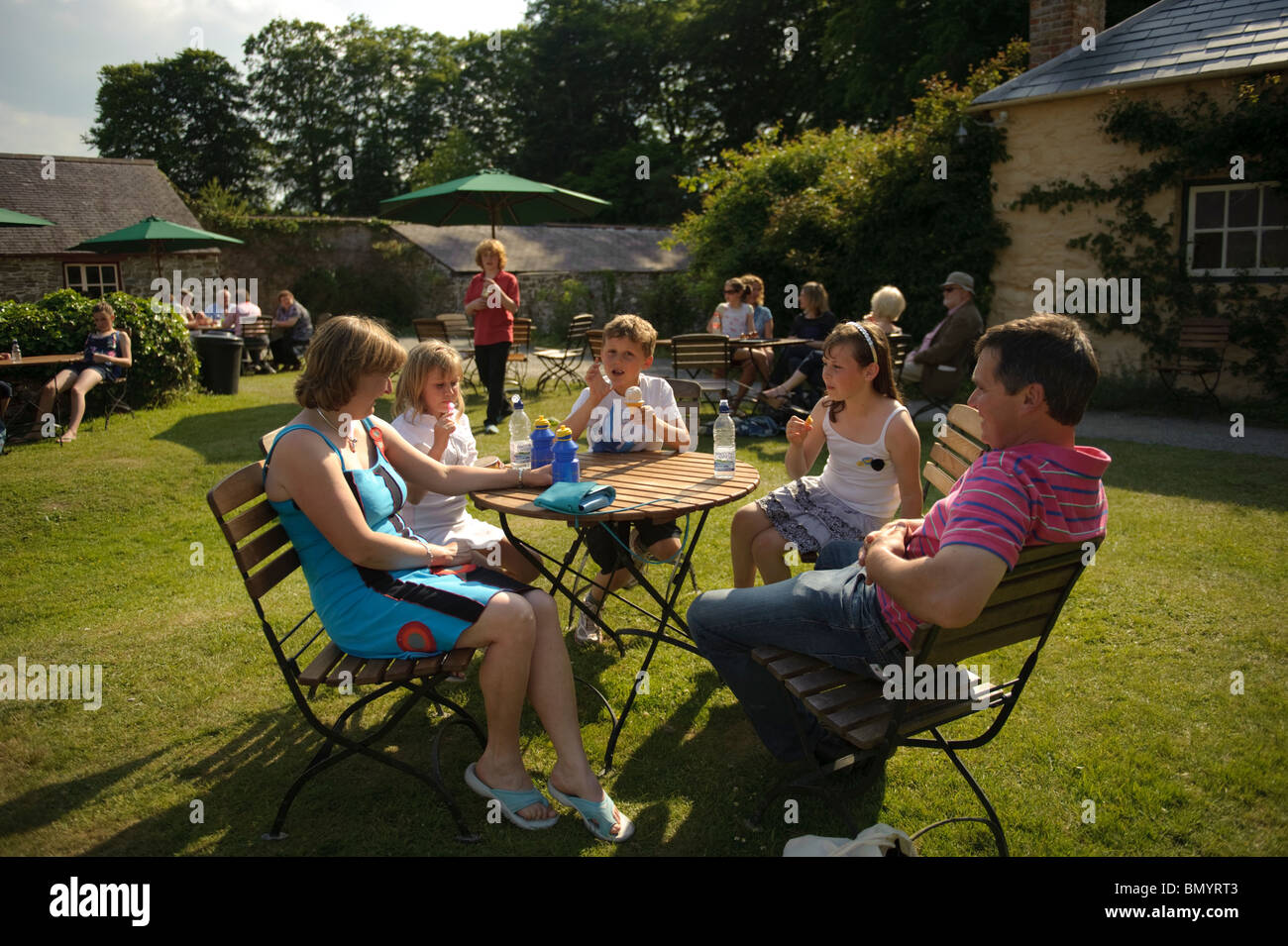 Une famille de visiteurs se détendre au soleil Llanerchaeron propriété du National Trust, Ceredigion, pays de Galles, Royaume-Uni Banque D'Images