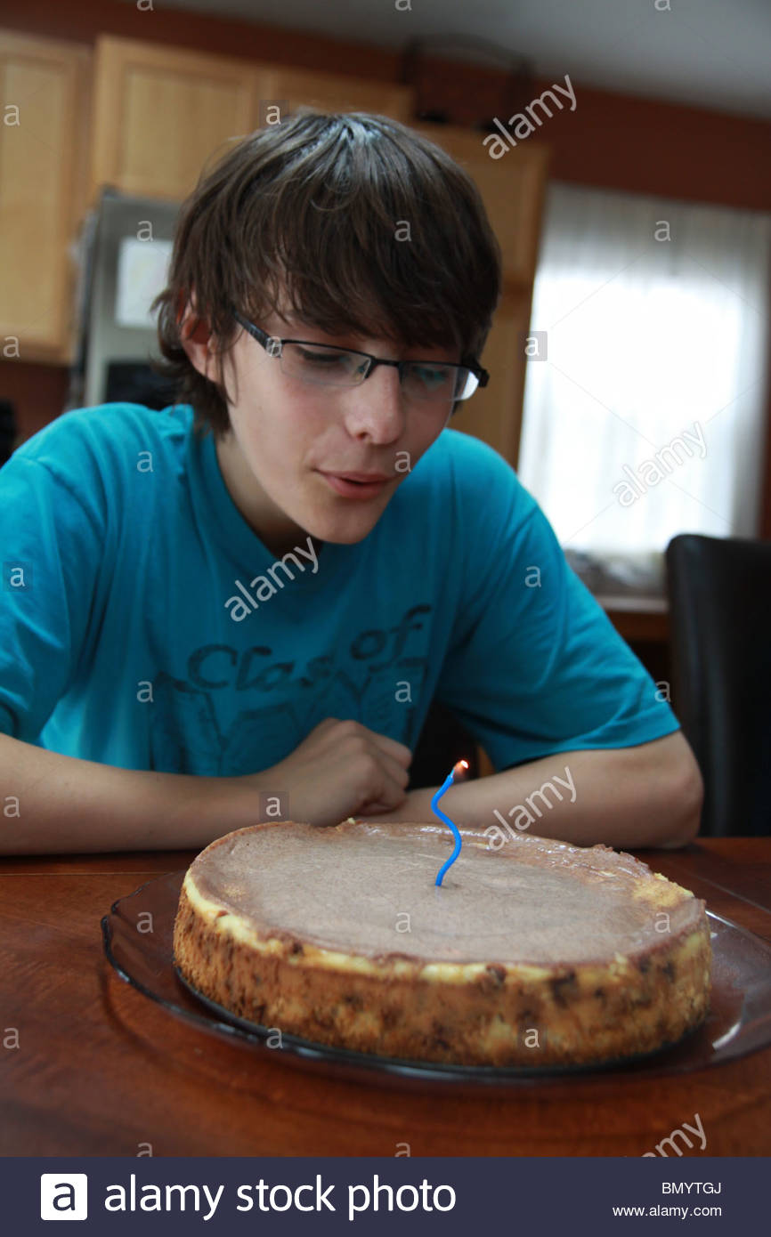Un Garcon De 14 Ans Souffler Une Bougie Sur Un Gateau D Anniversaire Photo Stock Alamy