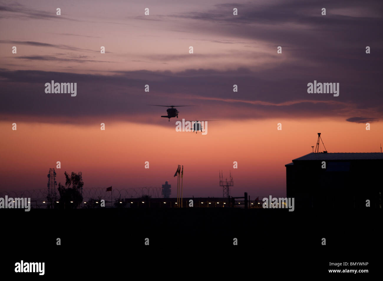 Une paire d'hélicoptères UH-60 Black Hawk leur approche à l'atterrissage pendant le coucher du soleil à Victory Pad, Bagdad, Irak. Banque D'Images