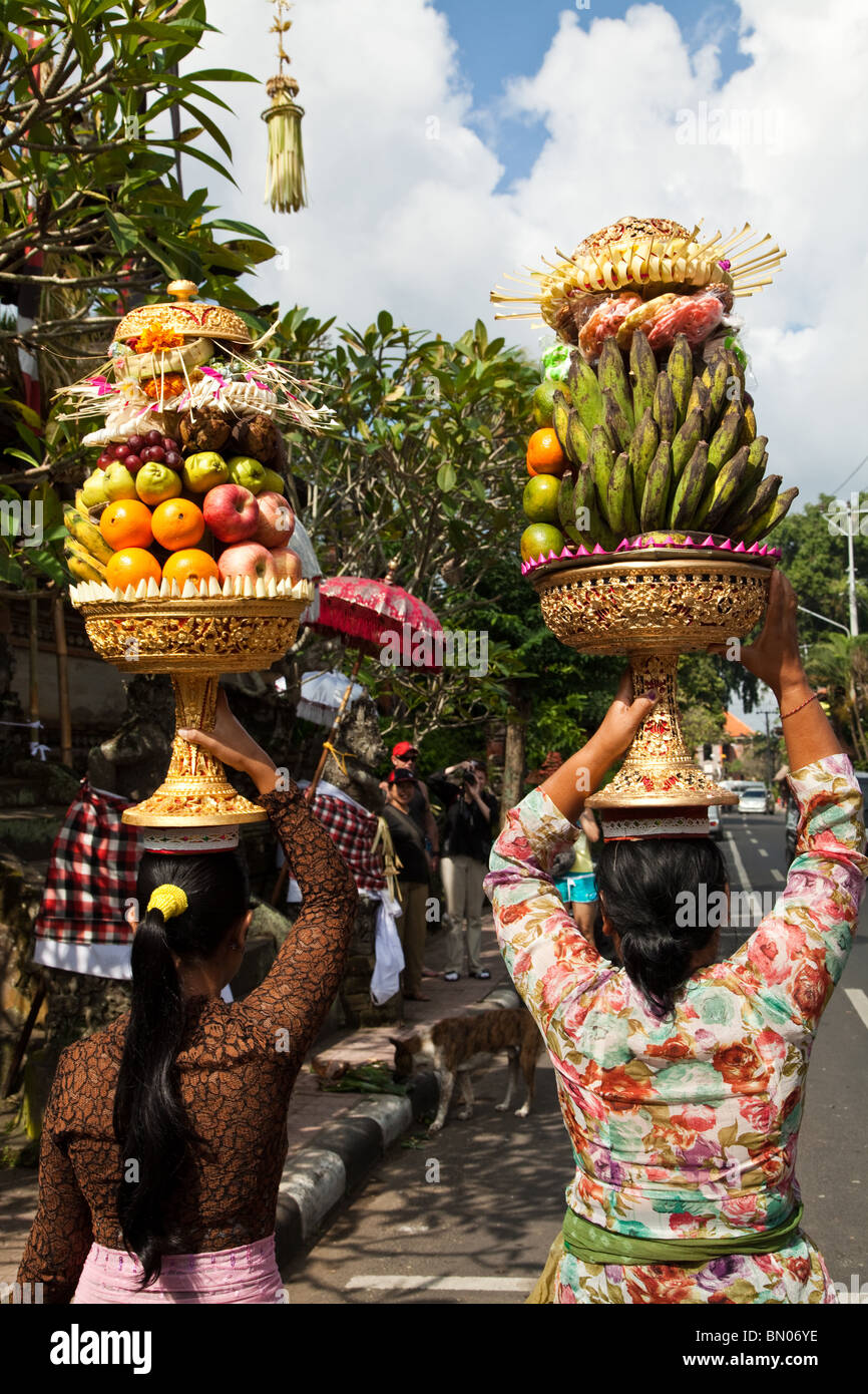 Les femmes avec gebogan balinais ou fruits disposés offrandes, faire leur chemin au Temple Hindou de Buda à Keliwon Pegatuwakan Banque D'Images