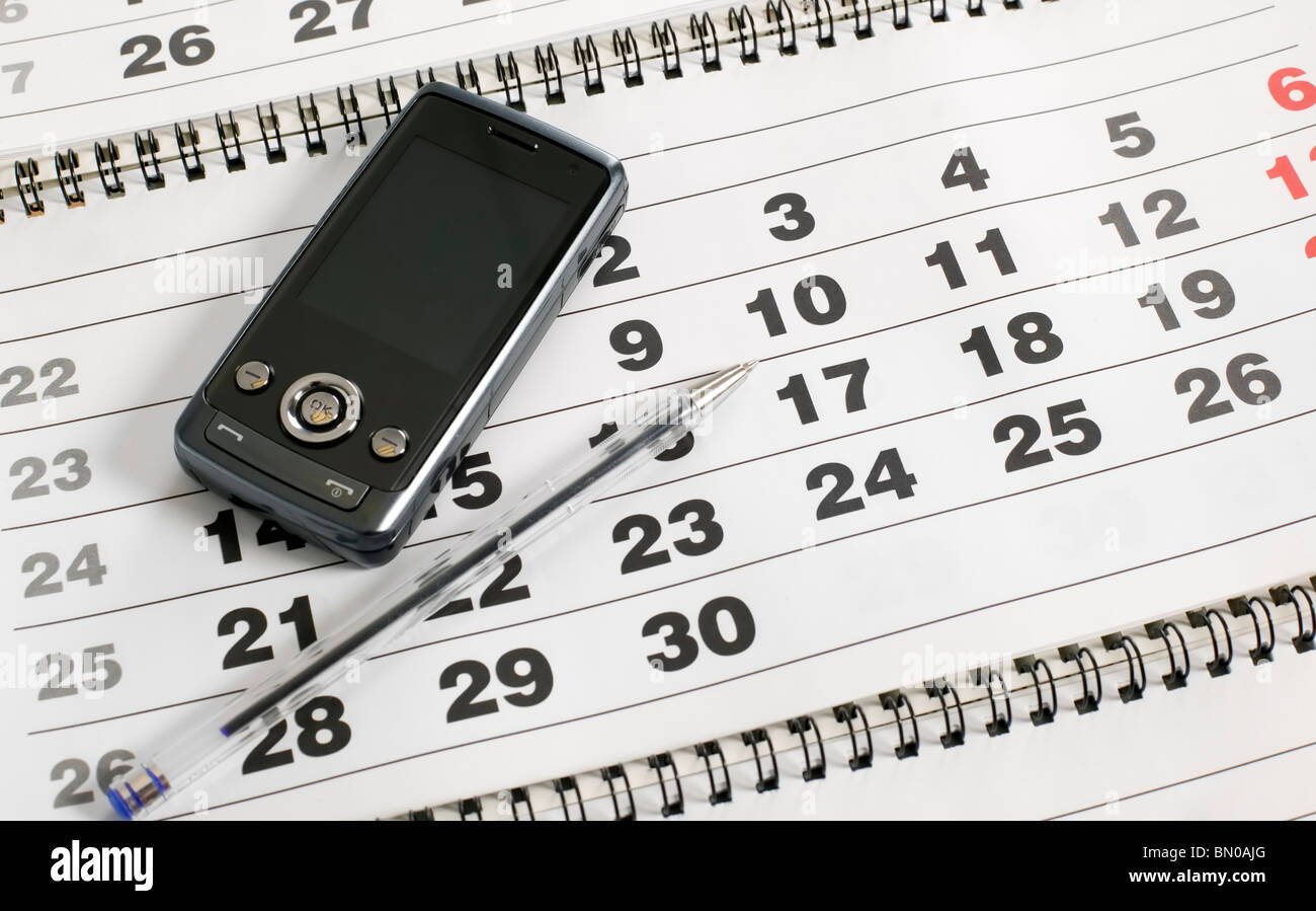 Téléphone portable et stylo est sur le calendrier Banque D'Images
