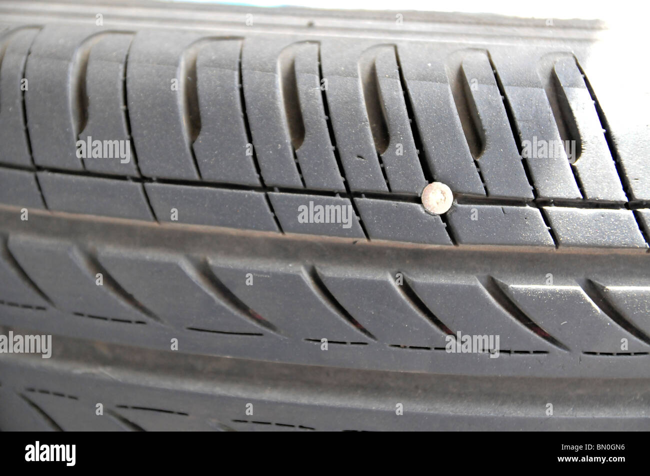 Pneu crevé - un clou intégré dans un pneu provoquant une fuite d'air Photo  Stock - Alamy