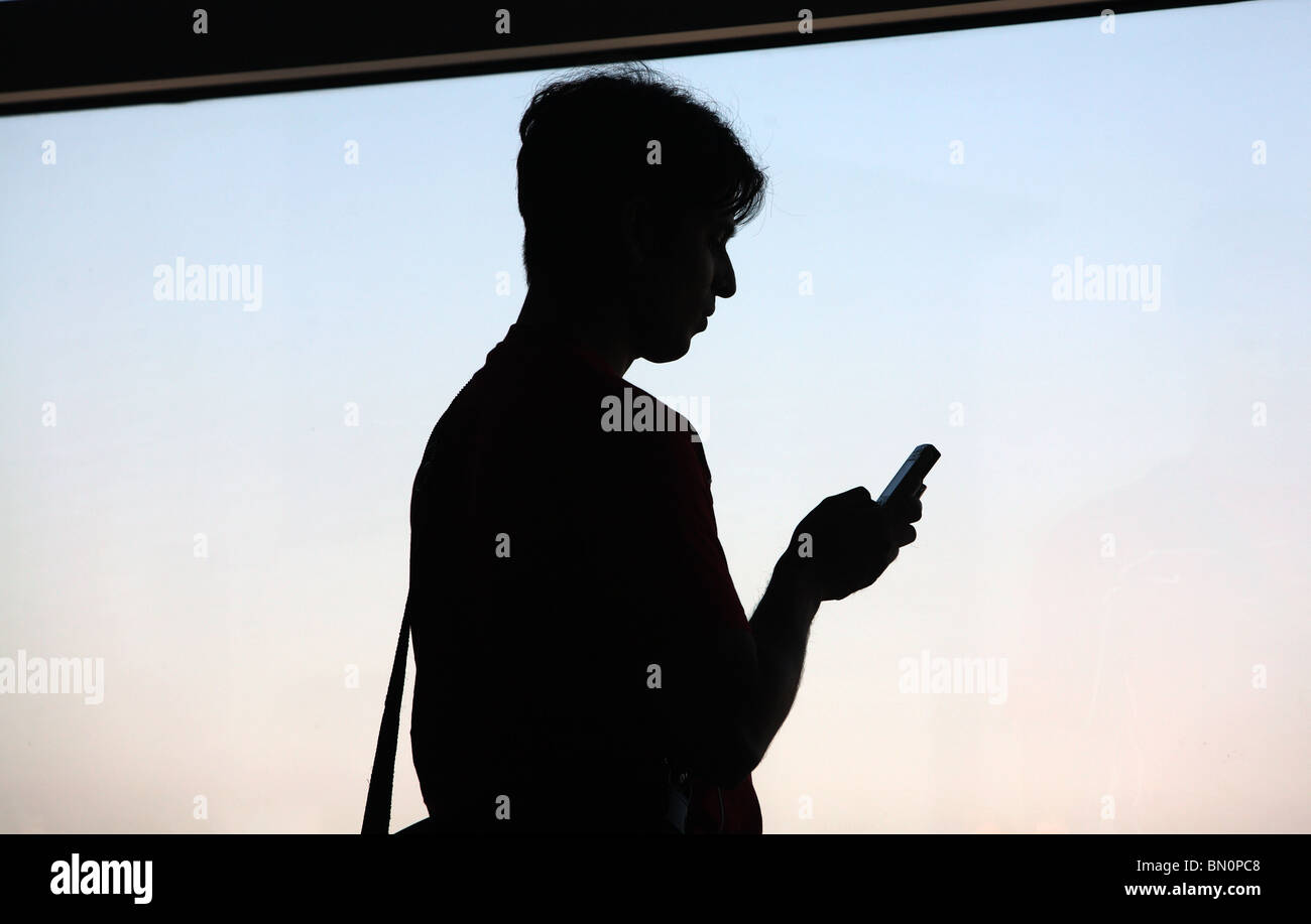 Silhouette d'un homme avec un téléphone mobile Banque D'Images