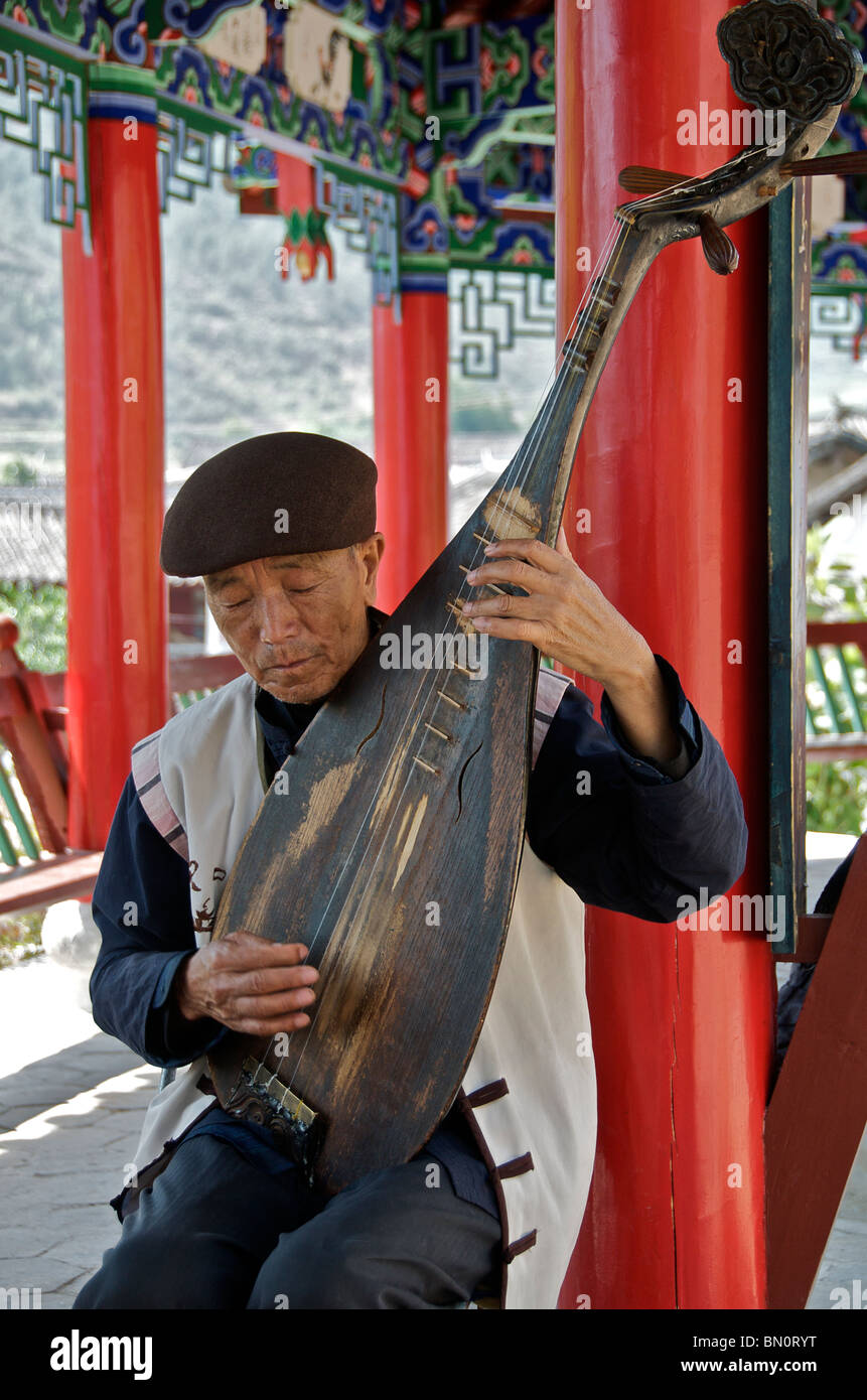 Homme jouant de la Pipa ou luth chinois Chine Yunnan Shiguzhen Banque D'Images