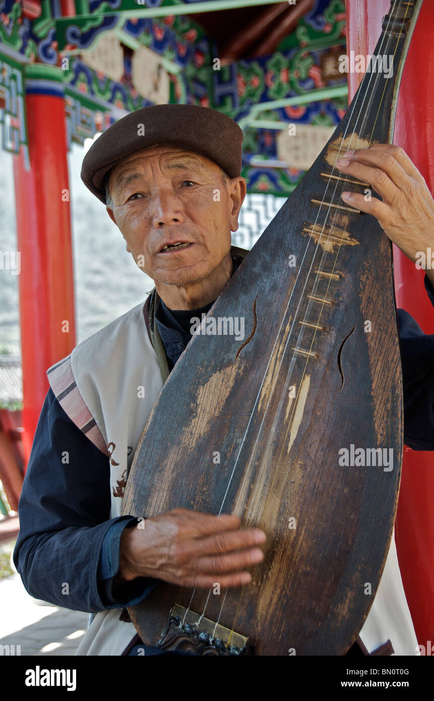 Homme jouant de la Pipa ou luth chinois Chine Yunnan Shiguzhen Banque D'Images