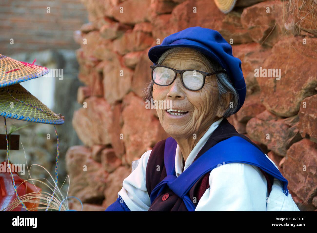 Portrait vieille femme vendant des chapeaux de paille fait main Shiguzhen Chine Yunnan Banque D'Images