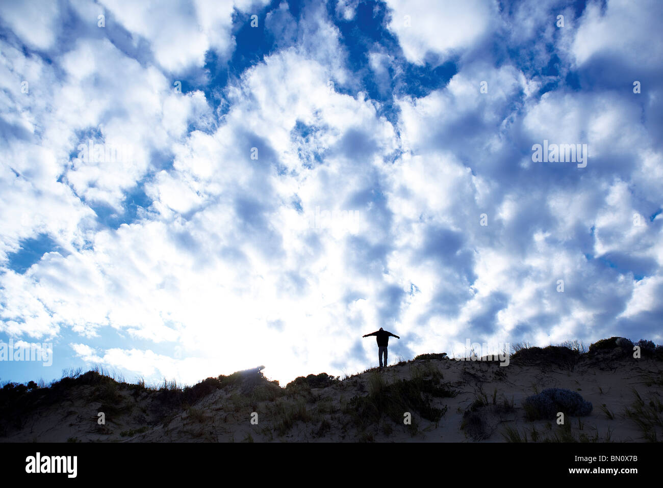 Jeune mec sur dunes en silhouette Banque D'Images