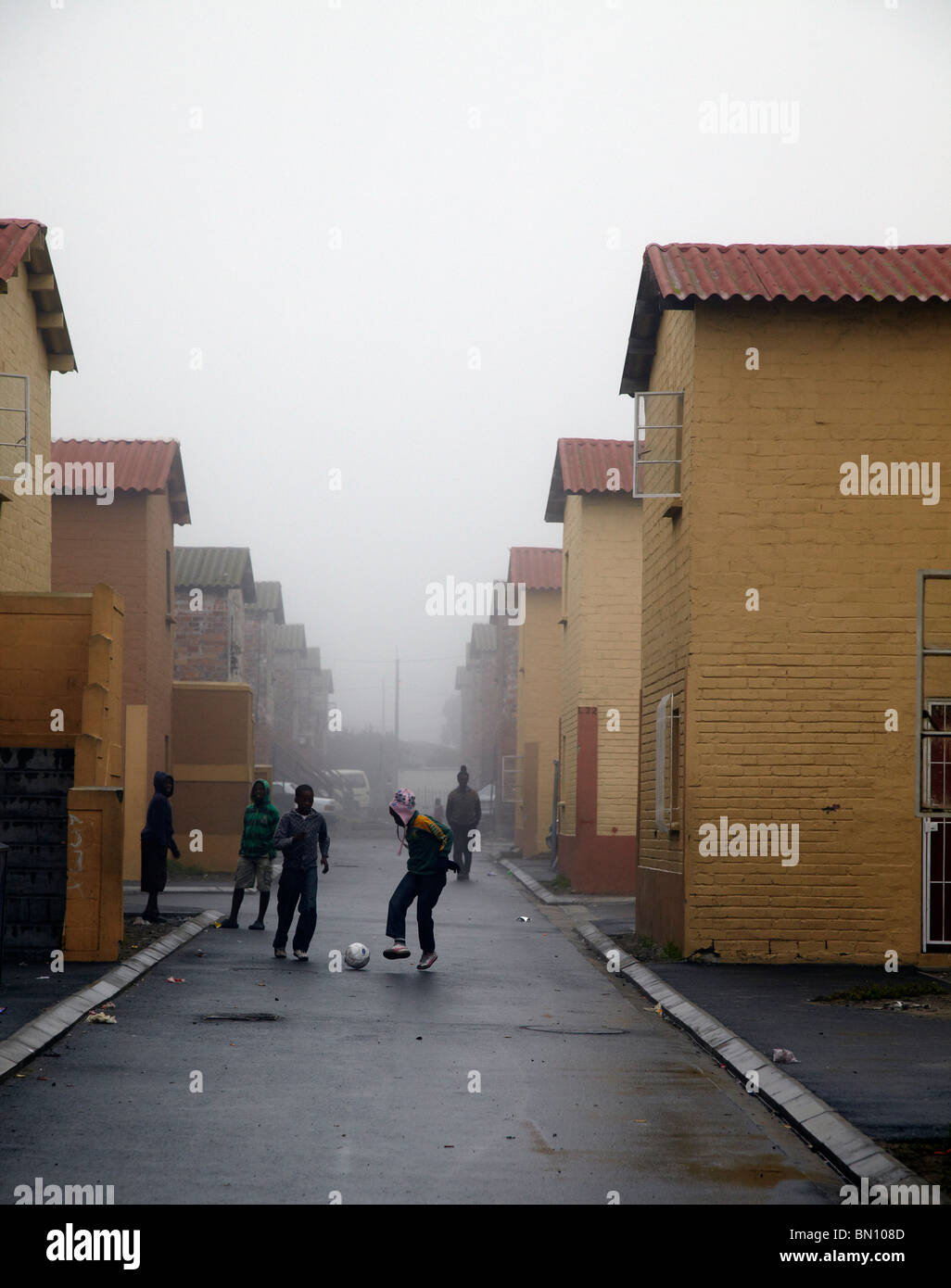 Les enfants jouent au football dans la rue, Langa township Banque D'Images