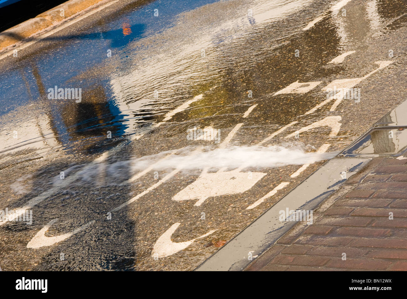 L'eau qui coule à travers la voie cyclable de refroidir les lignes de tram sur un pont d'Amsterdam, Banque D'Images