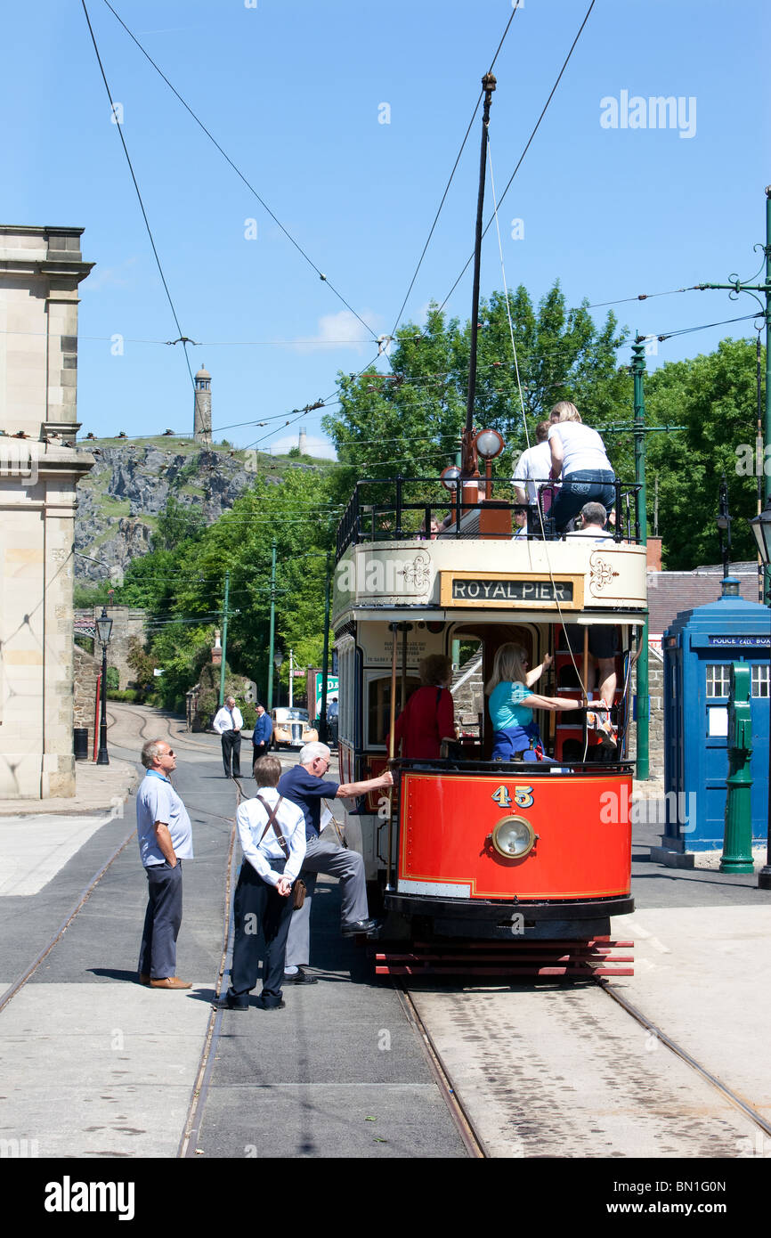 Les touristes à bord d'un tramway en face de l'ancien bâtiment de l'Assemblée Derby Chambres à Crich Tramway Museum dans le Peak District Banque D'Images