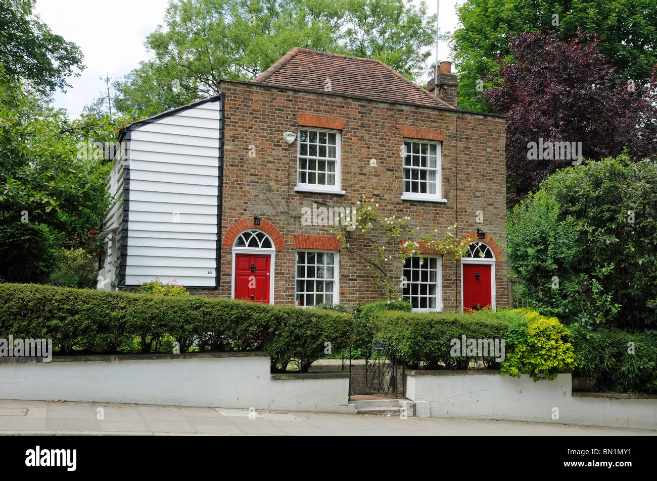 Smart semi-detached chalets en brique rouge et blanc avec des portes d'embarquement d'un côté météo, Highgate London England UK Banque D'Images