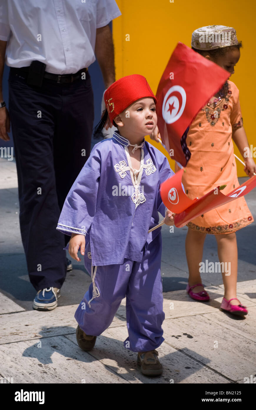 Un enfant dans un groupe de Tunisiens se prépare à mars dans le défilé des immigrants internationaux à New York Banque D'Images