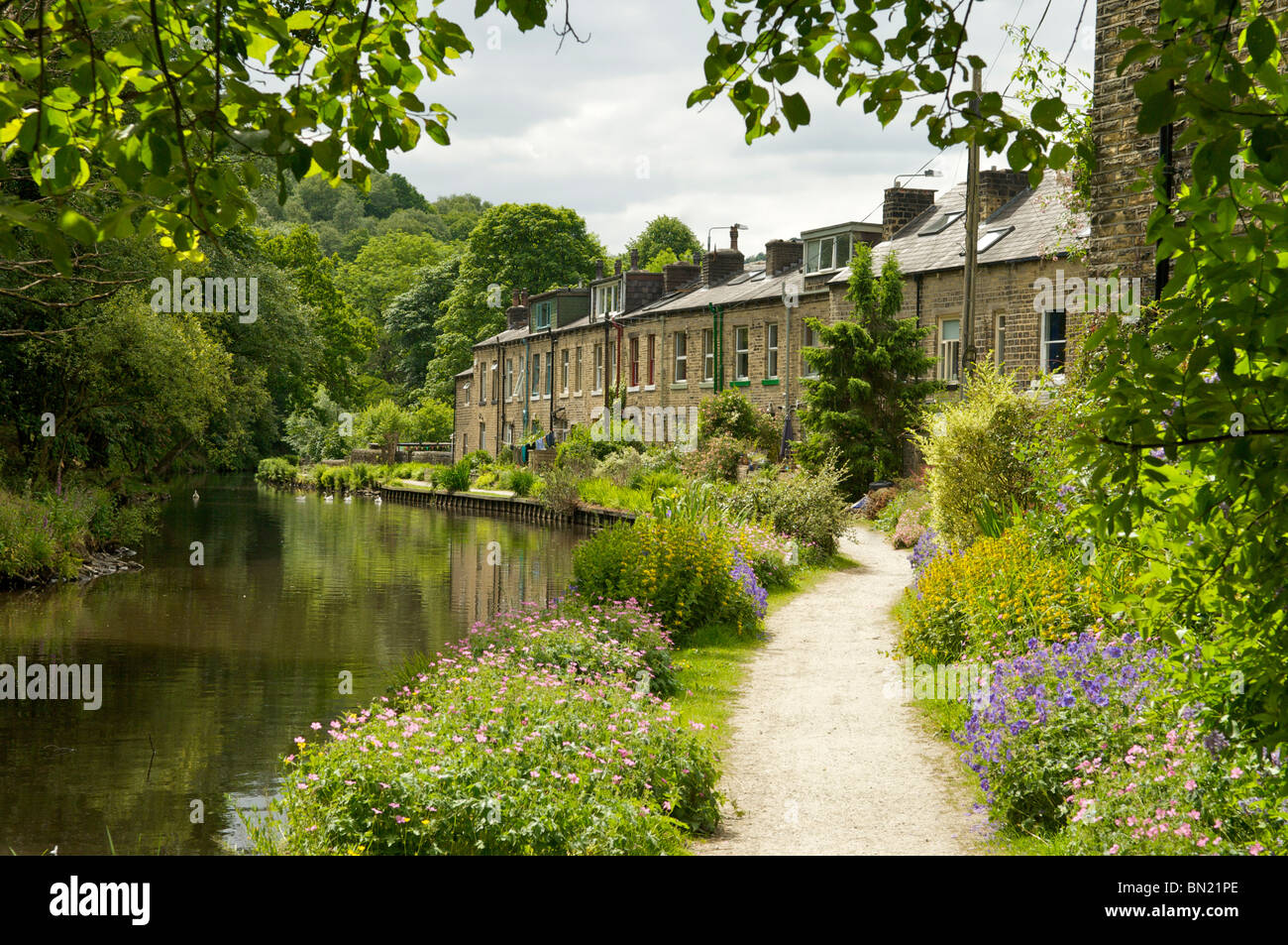 Construit en pierre des maisons en terrasse sur les rives de la Rochdale Canal au Yorkshire Hebden Bridge Banque D'Images