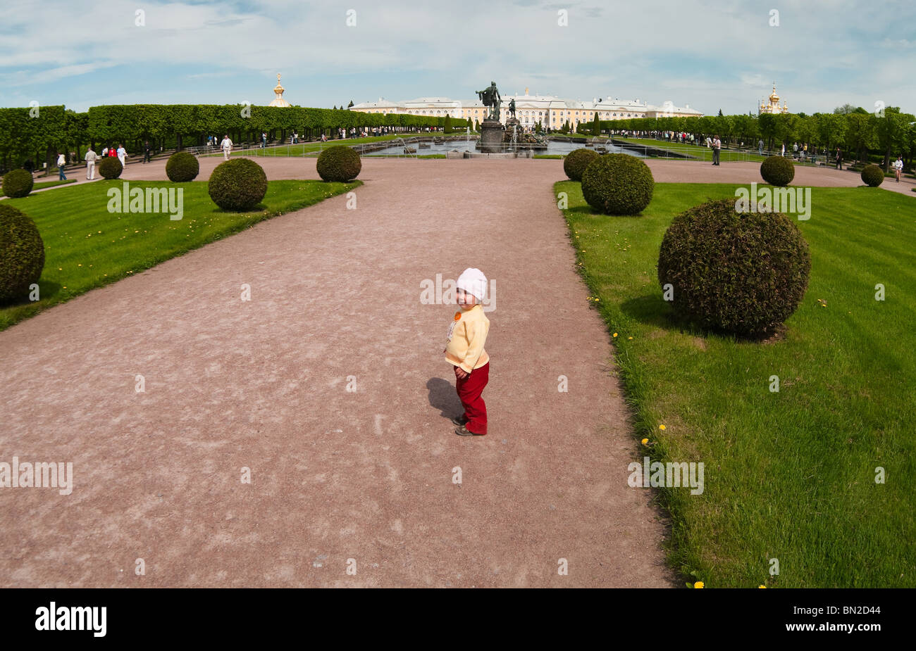 Les palais, les fontaines, et les jardins de Peterhof Grand Palais à Saint-Pétersbourg, Russie. Un enfant de marcher entre les plantes. Banque D'Images