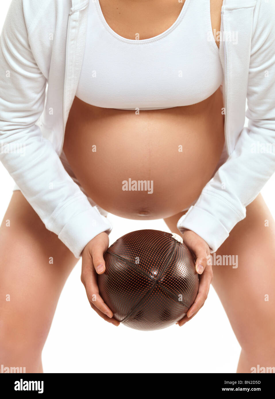Photo humoristique d'une jeune femme enceinte holding a football dans ses mains Banque D'Images