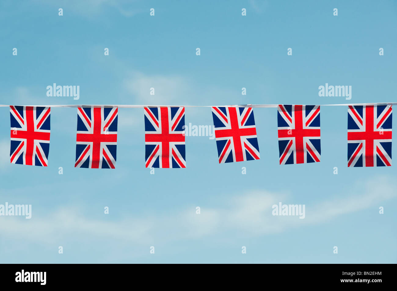 Union Jack flag bunting against a blue sky Banque D'Images