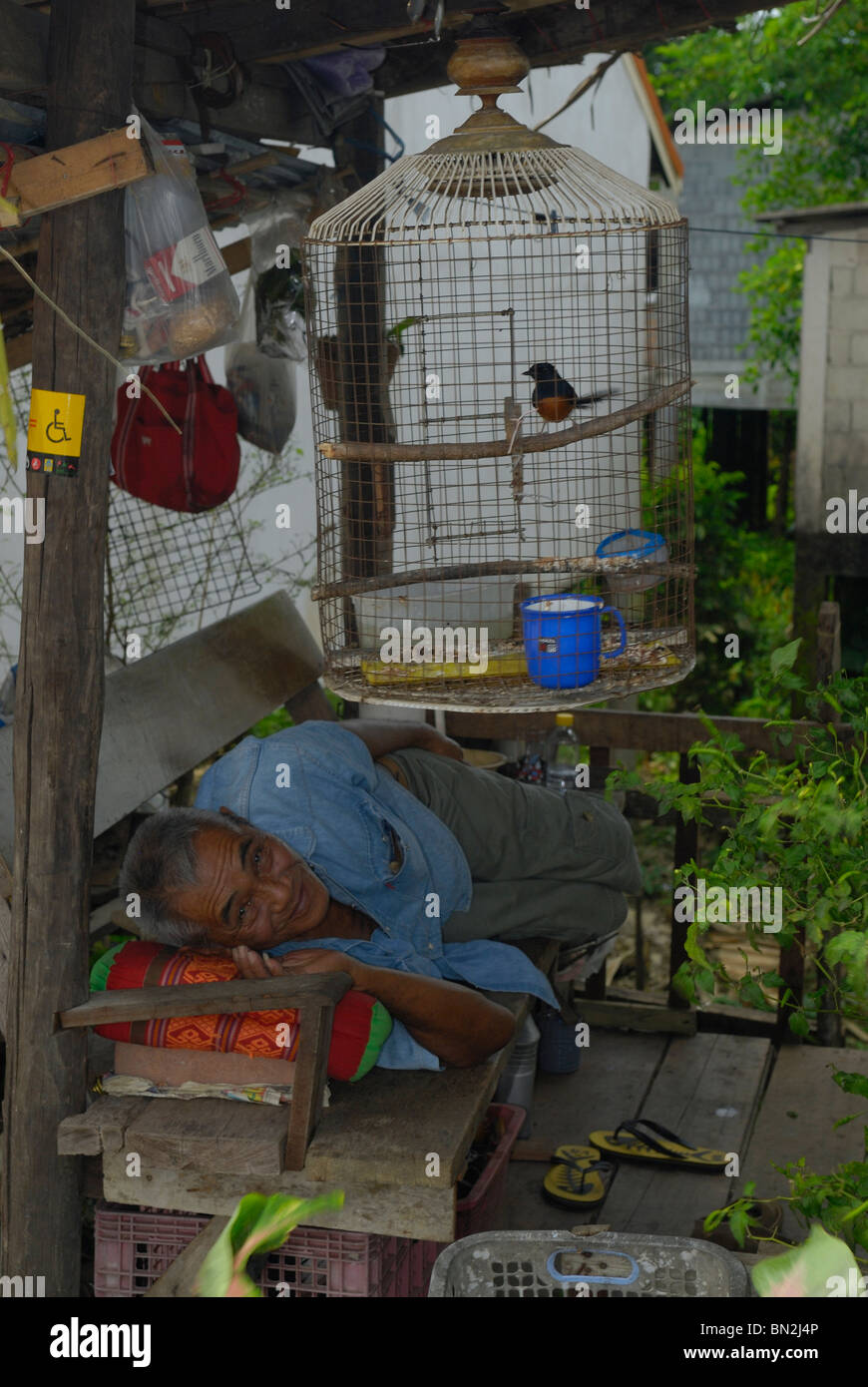 Vieil homme endormi sur un banc de la ville de Takua Pa, à l'ouest de la Thaïlande Banque D'Images