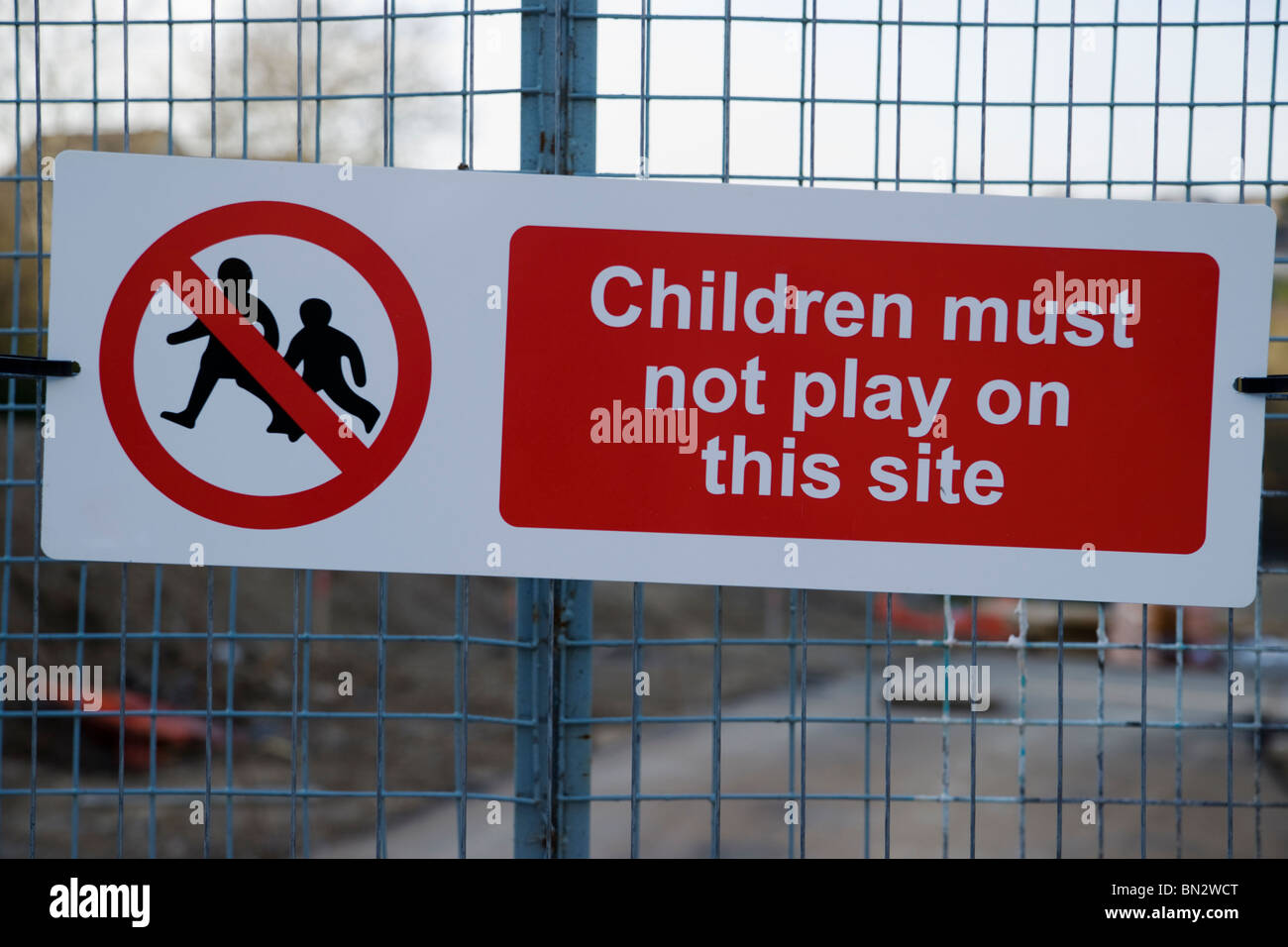 Les enfants ne doivent pas jouer avertissement attaché à un fil bleu mesh gate vue sur un chantier Banque D'Images