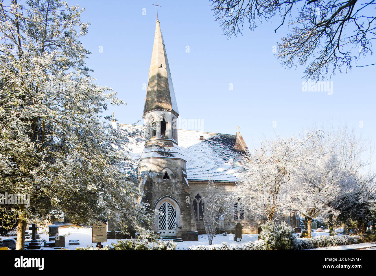 Neige de l'hiver à St John the Baptist Church dans le village de Cotswold Edge, Gloucestershire Banque D'Images