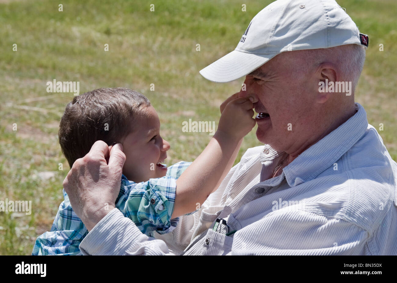 Eldlery homme jouant de pincer le nez avec son petit-fils Banque D'Images