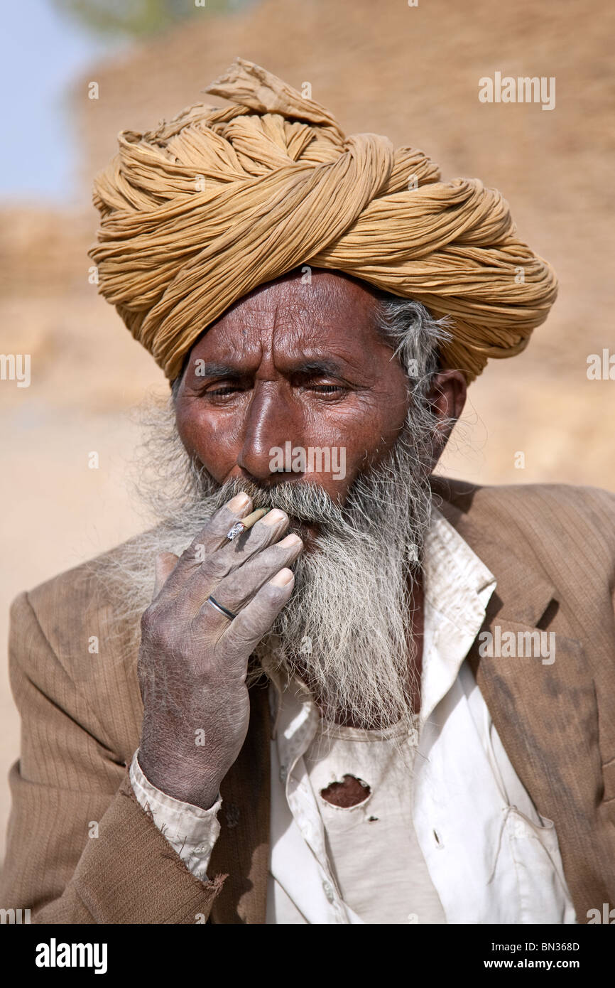 Old Indian man smoking a cigarette indienne (biri). Jaisalmer. Le Rajasthan. L'Inde Banque D'Images