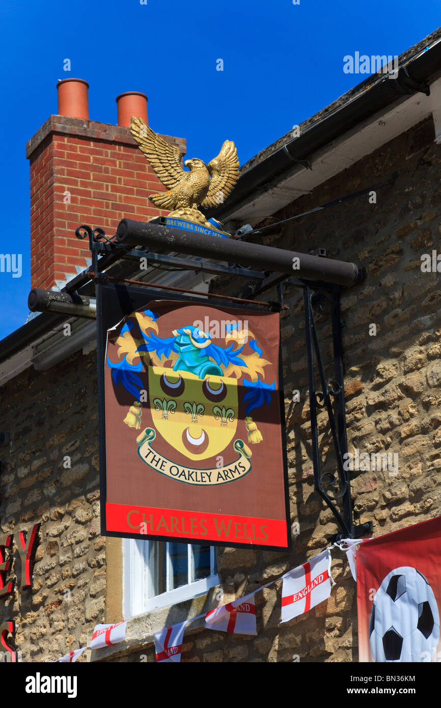 Le pub du village, le bras d'Oakley, signer surmontée d'un aigle doré de la Charles Wells Brewery, Harrold, Bedfordshire, Royaume-Uni Banque D'Images
